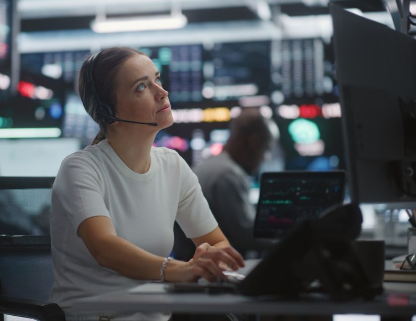 Compliance solutions for businesses hero image of woman in an operations centre surrounded by computer screens