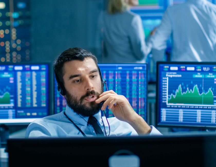 In-conversation assistant image of man with computer screens around him on a headset call