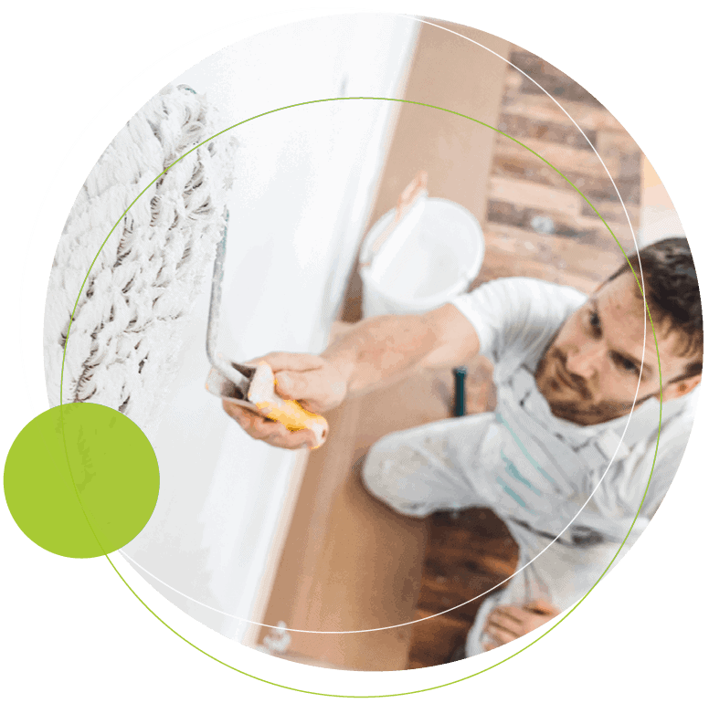 man using a paint roller on a wall)